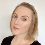 Professional headshot of a woman with short blonde hair and neutral makeup